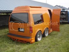 an orange van is parked in the grass