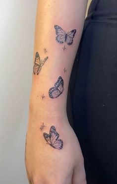 a woman's arm with butterflies and stars on the back of her left arm