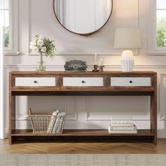 a console table with two drawers and a round mirror on the wall in front of it