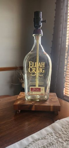 an empty glass bottle sitting on top of a wooden table