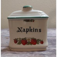 a ceramic jar with the word napkins on it and strawberries painted on it