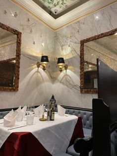 a dining room with two mirrors on the wall and a table in front of it