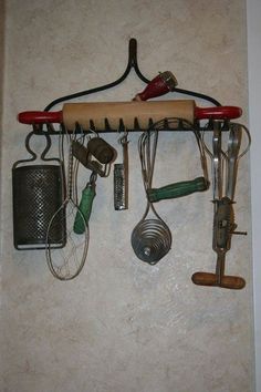 an assortment of kitchen utensils hanging on a wall