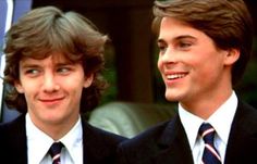 two young men wearing suits and ties standing next to each other