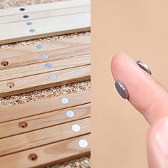 a person's finger is pointing at several holes in the floor