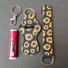 the key chain is next to an energy drink and a can opener with a sunflower pattern on it