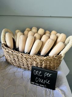 a basket filled with wooden baseball bats sitting on top of a table next to a sign