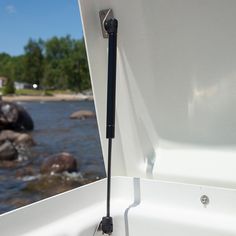 the front end of a boat with water and rocks in the background