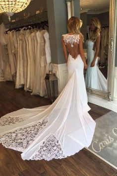 a woman is looking at her wedding dress in the mirror