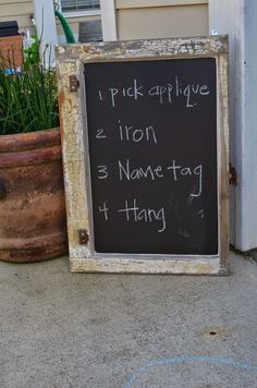 a chalkboard sign sitting on the sidewalk next to a potted plant