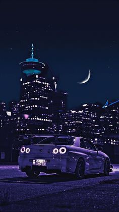 a car parked in front of a city at night