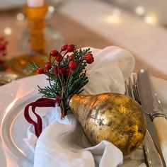 a white plate topped with a golden gourd next to a knife and fork