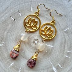 These earrings are comprised of gold plated lotus charms, Agate beads and gold wire-wrapped Leopardskin Jasper teardrops. They are 2.875'' in length including their gold plated ear wires and have a 2.5'' drop. At only 0.4 ounces, they are very lightweight and perfect for extended wear! Nickel and Lead Free.  ------------------------------ All of my jewelry pieces come in a stylish drawstring pouch, ready to wear or gift! Items will ship within 1-3 business days after an order is placed and are always packed with care & love in a pet-friendly home.  **Note** Jewelry items are not waterproof, therefore it is suggested to remove prior to bathing, swimming, etc. -------------------------------- Thanks for viewing this item!  Please contact me with any questions!  I do custom orders! ~Rachel~ T Gold Spiritual Beaded Earrings For Gifts, Gold Agate Teardrop Earrings, Gold Teardrop Agate Earrings, Gold Dangle Beaded Earrings With Natural Stones, Gold Teardrop Agate Jewelry, Gold Dangle Earrings With Gemstone Beads, Gold Beaded Earrings With Natural Stones For Gift, Gold Agate Earrings For Jewelry Making, Gold Drop Earrings With Natural Stones