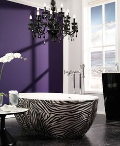 a bath tub sitting next to a window in a room with purple walls and flooring