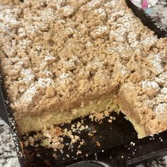 a close up of a cake in a pan on top of a counter with powdered sugar