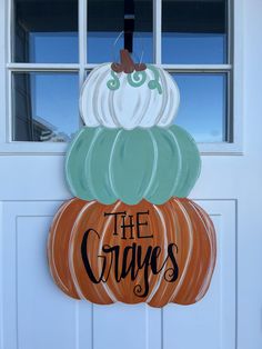 a wooden sign that says the crayos on top of a pumpkin sitting in front of a white door