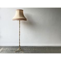 a floor lamp with a white shade on it's base and beaded lampshade