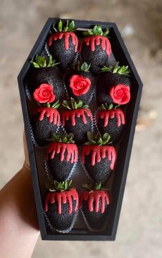 chocolate covered strawberries with red icing in a black box