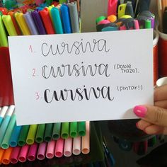 a person holding up a sign that says cursivaa, cursiva