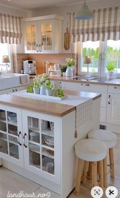 a kitchen with an island and stools in front of the counter top, next to a window