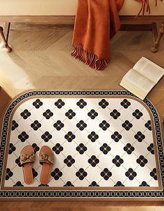 a pair of slippers sitting on top of a rug next to a book and chair