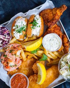 fish and chips with coleslaw, cole slaw, lemon wedges on the side