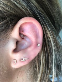 a close up of a person's ear with three piercings