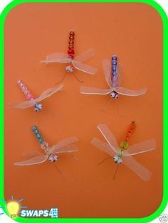 four dragonflys sitting on top of an orange surface