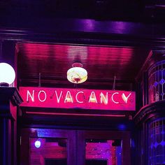 there is a neon sign that says no vacancy on the front of this building