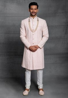 Art Silk Sherwani in Peach This Readymade Eyecaptivating attire is Enhanced with Buttons, Resham, Dori and Sequins Work and is Crafted in Chinese Collar Neck and Full Sleeve Available with an Art Silk Churidar in Cream Do note: Kanthimala and Footwear shown in the image is for presentation purposes only. Half to one inch may vary in measurement. (Slight variation in actual color vs. image is possible) Indian Groom Dress, Silk Churidar, Mens Indian Wear, Embroidered Sherwani, Wedding Outfits For Groom, Embroidered Art, Utsav Fashion, Pink Men, Modest Wear