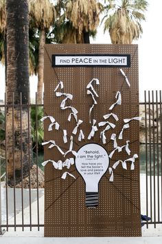 a sign that has been placed in front of a fence with birds flying around it