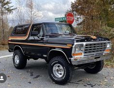 a black truck parked in front of a stop sign