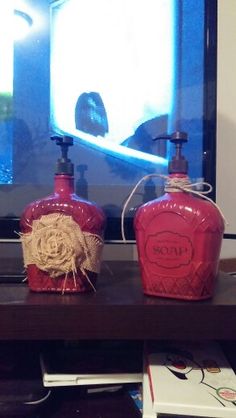 three red soap dispensers sitting on top of a wooden table in front of a tv