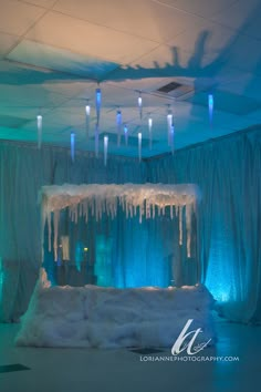 an ice - covered stage set up with blue lights and icicles hanging from the ceiling