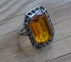 This dainty ring is set with a lovely citrine glass gem surrounded by small white rhinestones, condition is good overall and size is ~3.5. Condition is very good except for the darkening of the white stones and some plating loss on the back of the band. Item is sold as-is. We welcome haggling in this shop! Silver Ring For Vintage Events, Art Deco Yellow Jewelry As A Gift, Art Deco Yellow Jewelry Gift, Silver Vintage Crystal Ring Collectible, Vintage Silver Jewelry With Accent Stones, Art Deco Citrine Jewelry For Anniversary, Antique Yellow Jewelry For Wedding, Art Deco Yellow Collectible Jewelry, Art Deco Citrine Rings In Yellow