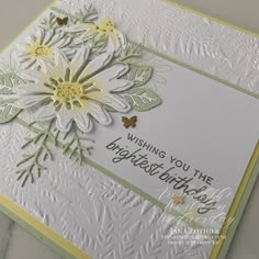 a close up of a greeting card with flowers on the front and bottom, which reads wishing you the brightest birthday