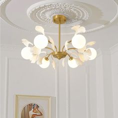 a chandelier hanging from the ceiling in a room with paintings on the walls