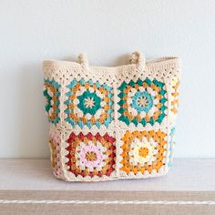 a crocheted bag sitting on top of a table next to a white wall