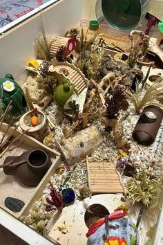 an assortment of items are displayed in a box on the floor, including pots and bowls