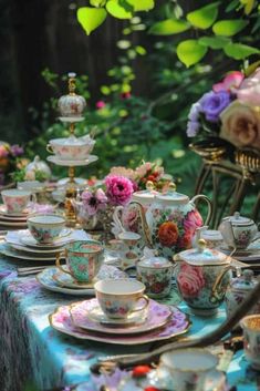 the table is set with tea cups and saucers