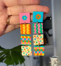 a person is holding some colorful earrings in their hand and it looks like they have been made out of legos