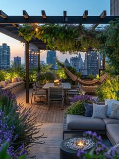 an outdoor living area with lots of furniture and plants on the roof terrace at dusk