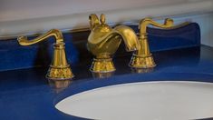 a gold faucet on a blue counter top