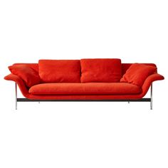 an orange couch with red pillows on it