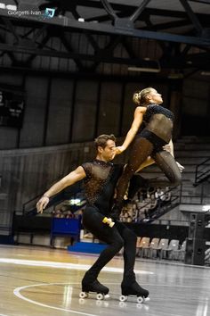 two people on skateboards in an indoor arena