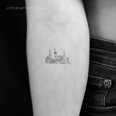 a small city skyline tattoo on the left arm