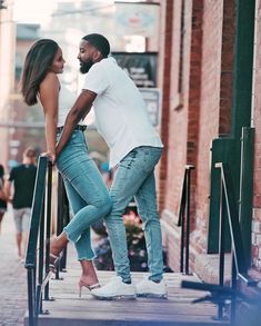 a man and woman leaning against the railing