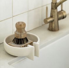 a bathroom sink with a brush and soap dispenser