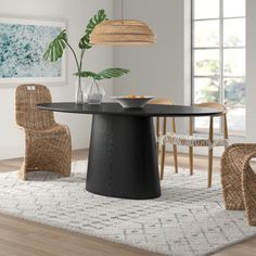 a dining room table and chairs in front of a window with an area rug on the floor