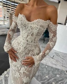 a woman in a wedding dress posing for the camera with her hands on her hips